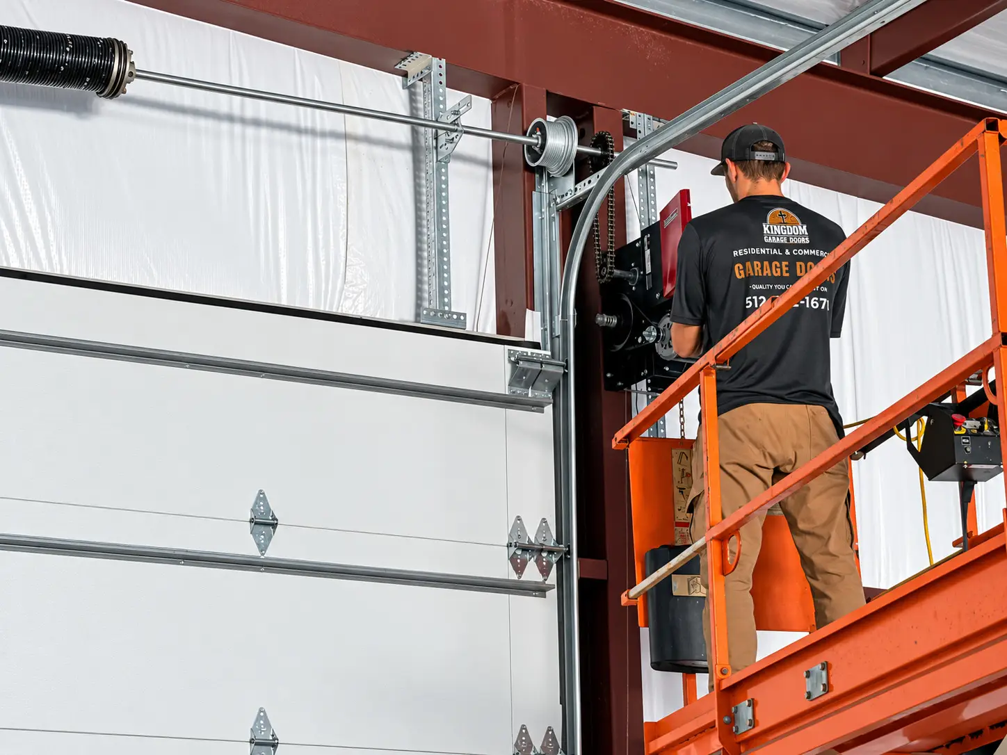 Kingdom technician installing a commercial overhead door