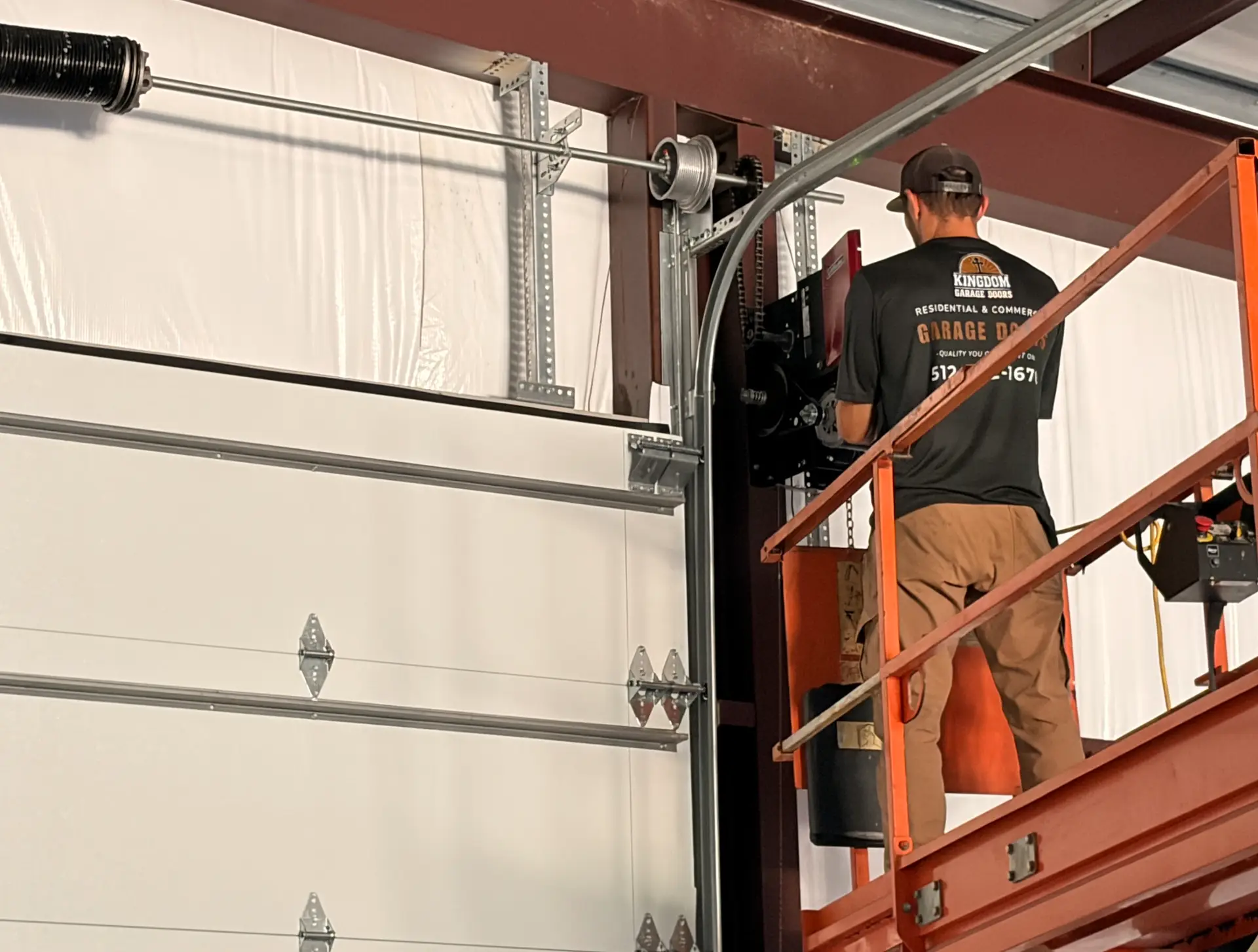 Kingdom Garage Doors technicians servicing overhead door hardware